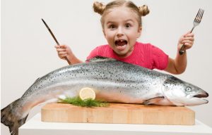 enfant-mange-gros-poisson-photo